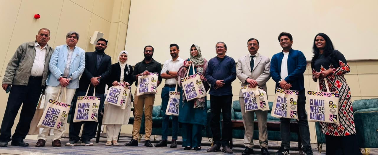 Event participants holding illustrated tote bags on stage